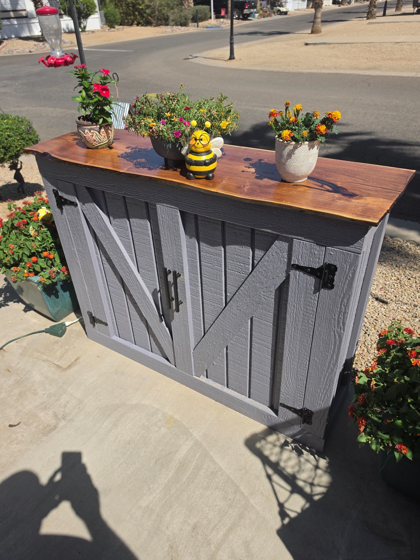 Gray outdoor TV lift cabinet with wood top