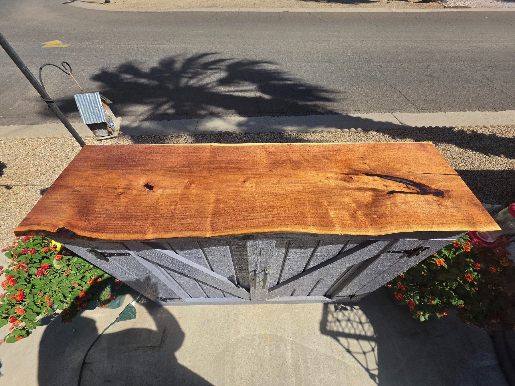 Live edge wood top on outdoor TV cabinet